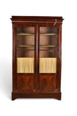 une bibliothèque ancienne en acajou avec des portes vitrées et des étagères