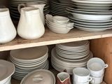 many plates and bowls on the shelves in the kitchen