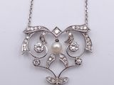 a close up of a necklace with a pearl and diamonds