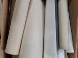 many rolls of paper in a cardboard box on the floor