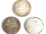 three different types of coins are shown on a white surface