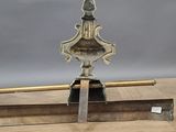 an antique brass plate with a wooden handle on a wooden table