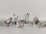 figurines d'oiseaux et vases plaqués argent sur un fond blanc