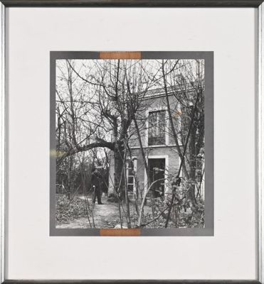 black and white photograph of a man standing in front of a house