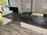 a black marble counter top in a kitchen with white cabinets