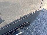 a close up of a car ' s rear end with a reflection of a building in the background