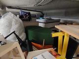 a pile of clutter in a cluttered room with a book on the floor