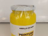 un pot de peinture jaune posé sur un plan de travail