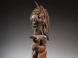 une image représentant une sculpture en bois d'un homme dont la tête est celle d'une chèvre