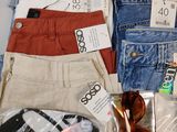 several pairs of jeans and sunglasses are laid out on a table