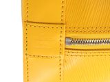 a close up of a yellow purse on a white background