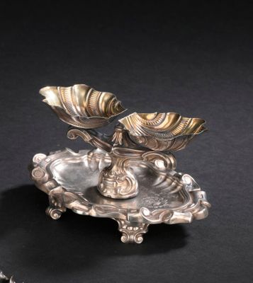 une assiette en argent ornée d'une fleur sur un fond noir