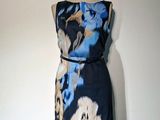 une robe posée sur un mannequin, ornée d'un imprimé floral bleu et blanc