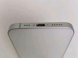 the back of a silver cell phone sitting on top of a table