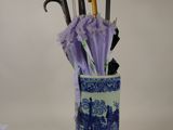 un vase bleu et blanc contenant des parapluies et des manches de parapluie