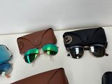 three pairs of sunglasses and a case are sitting on a table