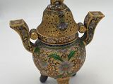 a close up of a teapot with a bird on top of it