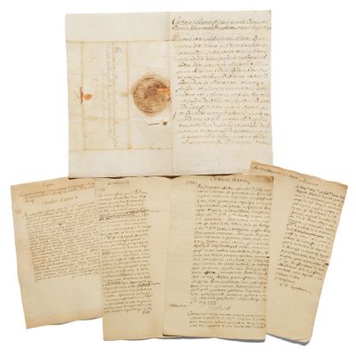 une pile de vieux papiers couverts d'écriture, posée sur une surface blanche