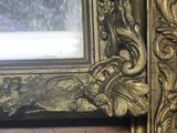 an ornate gold frame with a mirror in the middle of it