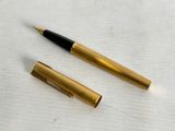 a close up of a pen and a ballpoint pen on a table