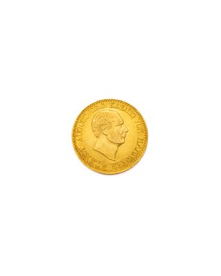 gros plan d'une pièce d'or sur une surface blanche