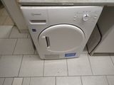une machine à laver et un sèche-linge blancs posés sur un sol carrelé