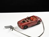 une petite voiture rouge branchée sur un chargeur