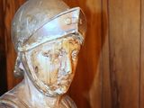 a statue of a man wearing a helmet and holding a sword