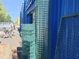 a blue building that has a bunch of green mesh on the side of it