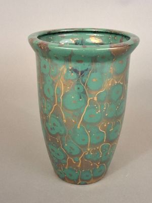 a green vase with gold and blue designs on it