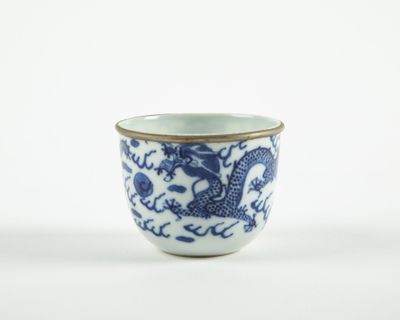 une tasse bleue et blanche ornée d'un motif représentant un dragon