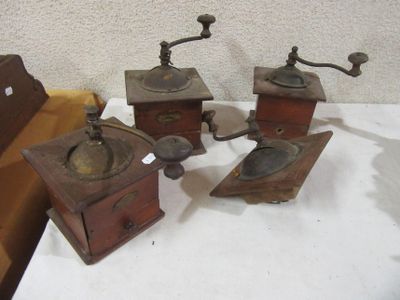 three old fashioned coffee grinders are sitting on a table