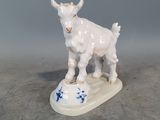 une petite figurine représentant une chèvre, posée sur un socle blanc