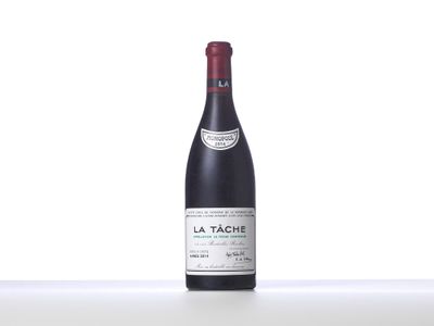 a bottle of red wine sitting on top of a white table