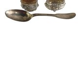 silver spoon and spoon rest with a bowl and spoon on a white background