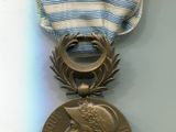une médaille entourée d'un ruban, posée sur un fond blanc