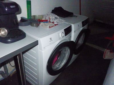 une machine à laver et un sèche-linge posés sur un plan de travail dans une pièce