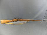 a rifle that is sitting on a gray surface