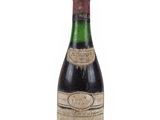 une vieille bouteille de vin posée sur une surface blanche