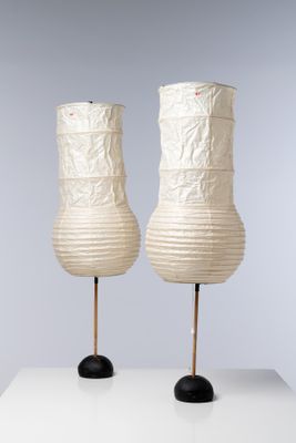 une paire de lanternes en papier blanc posées sur une table blanche