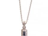 un pendentif en forme de croix en or blanc, serti de diamants noirs, monté sur une chaîne