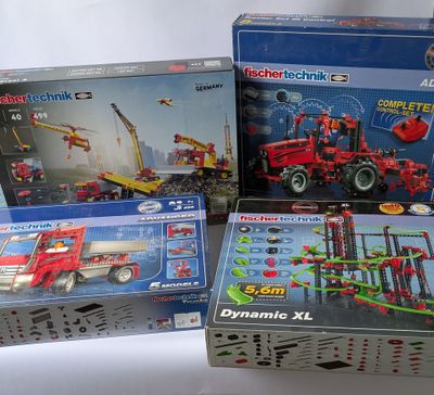 trois boîtes de legos de tailles et de couleurs différentes sur une surface blanche