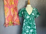two dresses on a mannequin stand next to each other