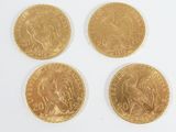four different types of gold coins sitting on top of a white surface