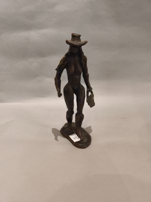 statue d'un homme coiffé d'un chapeau, debout sur un skateboard posé sur une surface blanche