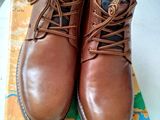 une paire de chaussures marron posée sur une carte