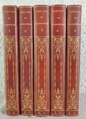 cinq livres rouges sont alignés en rang sur une table