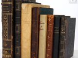 several old books are stacked on top of each other on a table