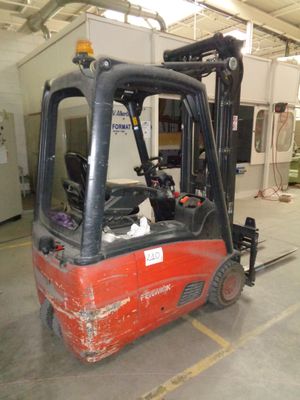a red fork truck parked inside of a building