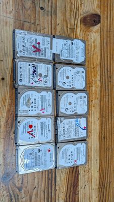 Plusieurs disques durs sont empilés les uns sur les autres sur une surface en bois